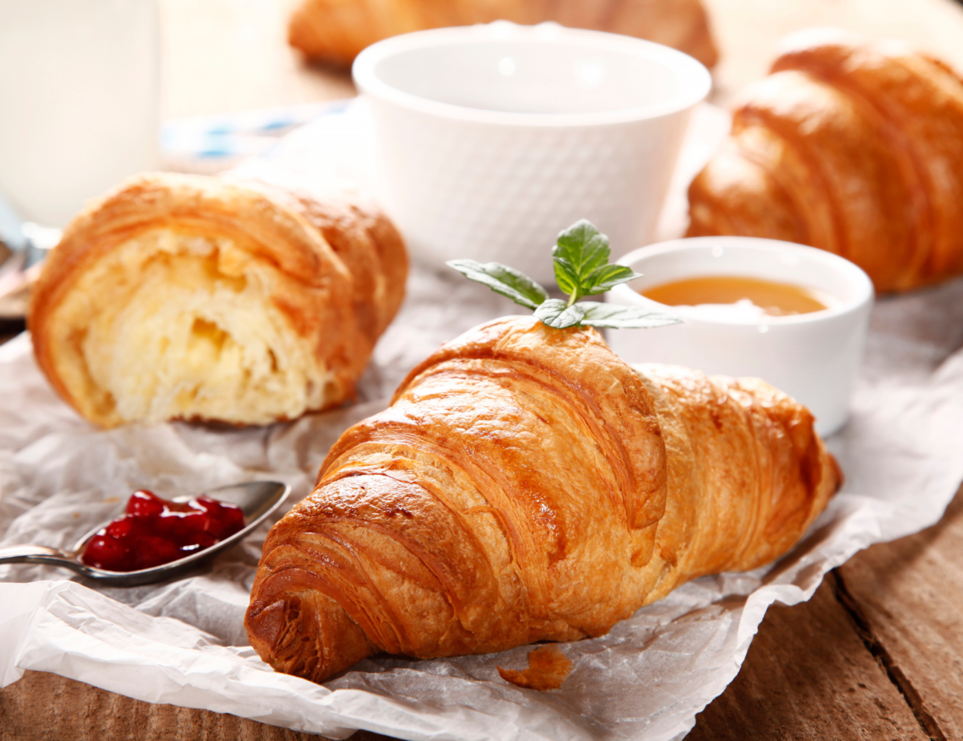 Croissants and cups of honey on a white cloth on a table. Croissant are perfect breakfast at Fraise Cafe in Fullerton, CA.